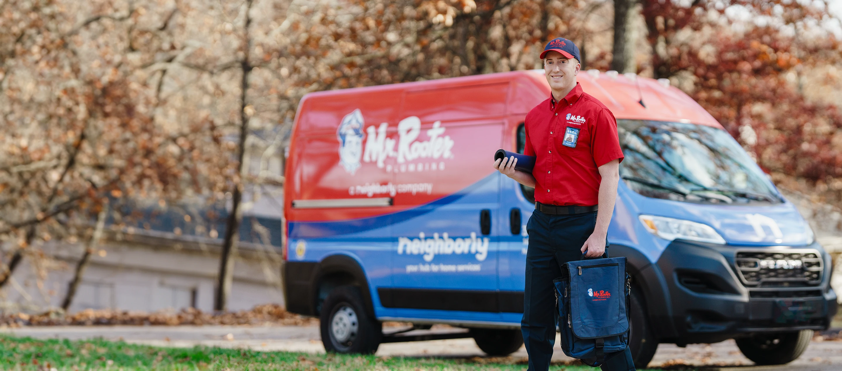 Mr. Rooter service professional standing beside a branded van